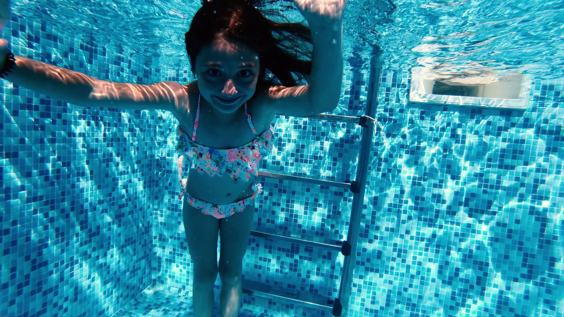 可爱的小女孩在游泳池的水下做了一个傻脸视频的预览图