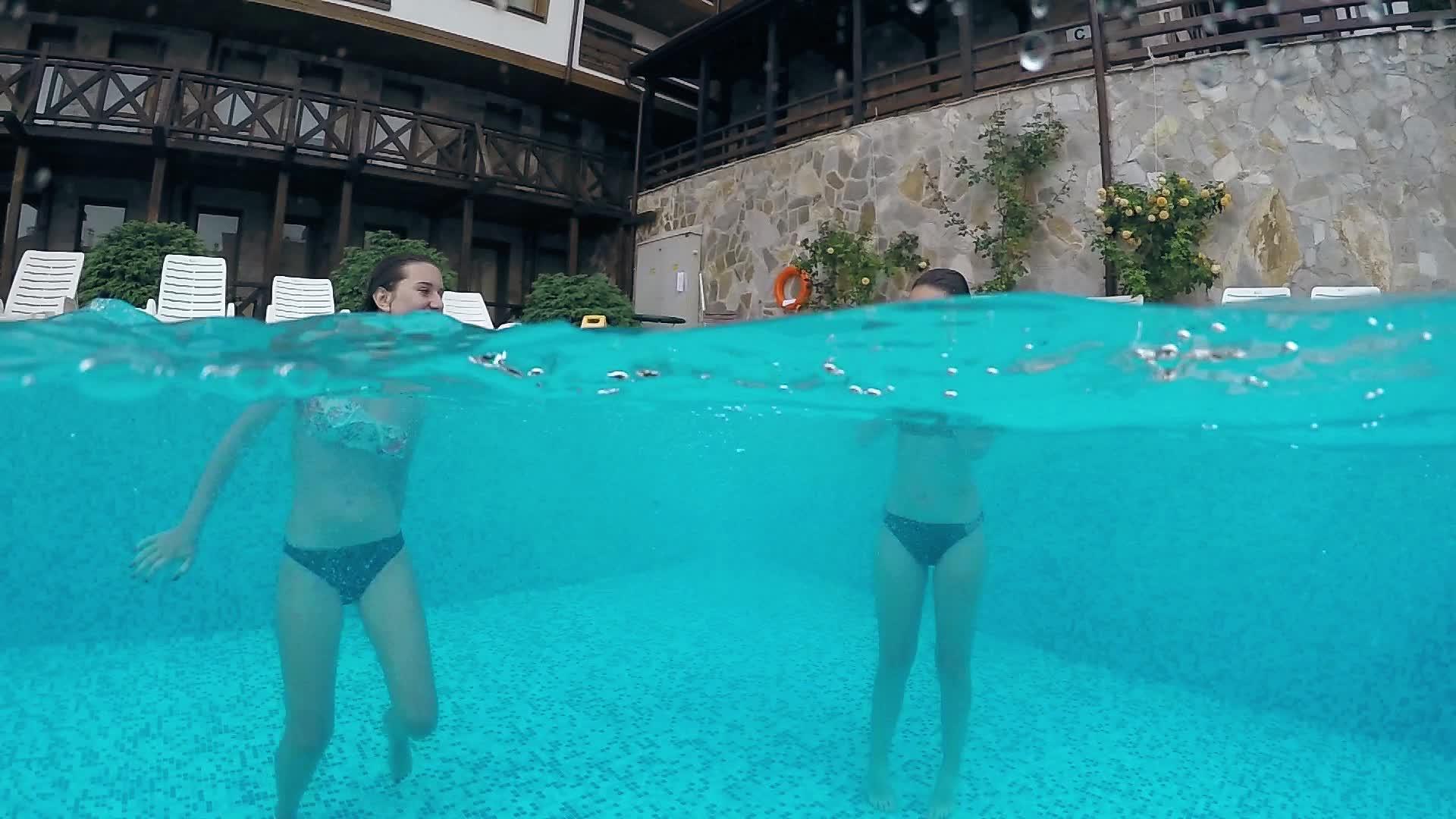 两个快乐的女孩在豪华游泳池里快乐地游泳和喷水视频的预览图