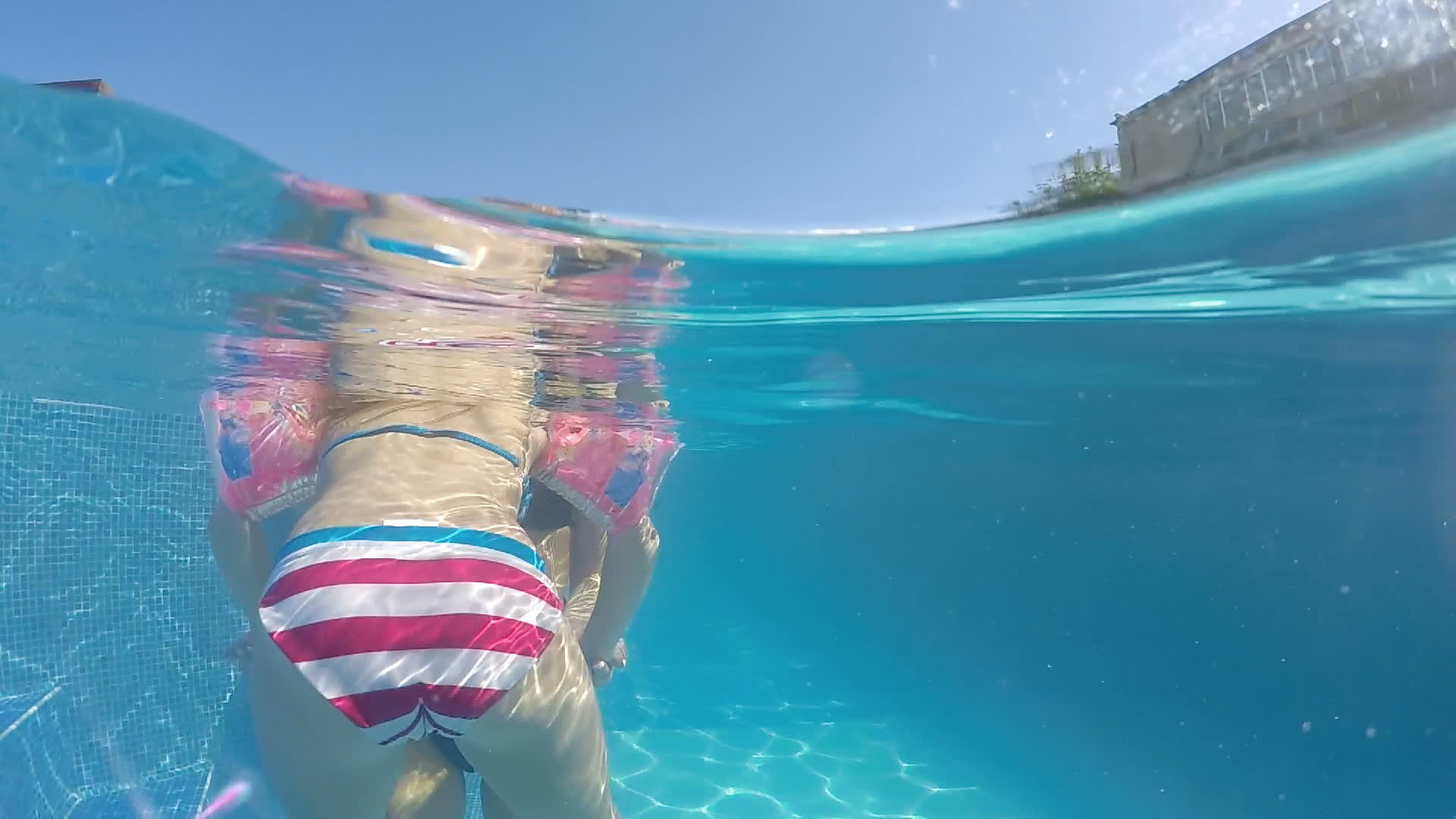 一个手臂可爱的小女孩学会了在水下游泳池和母亲一起游泳视频的预览图