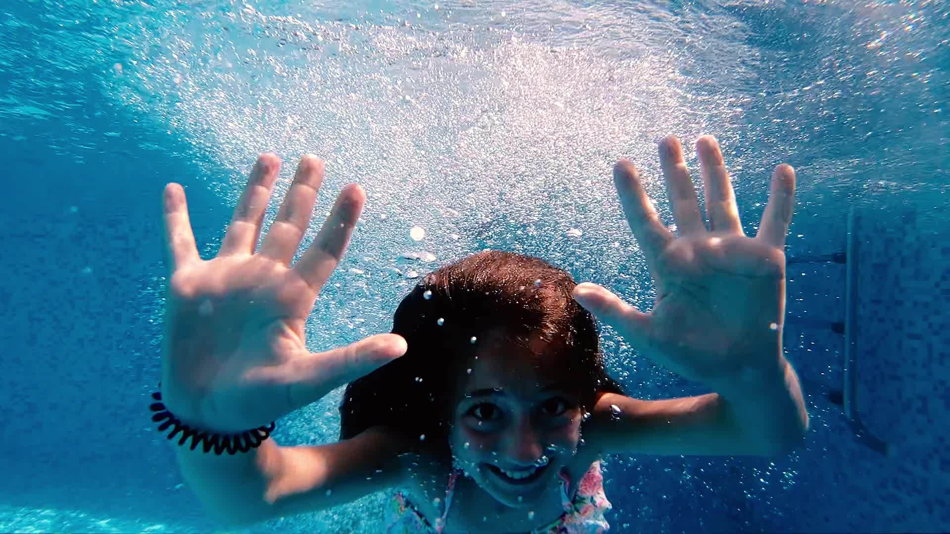 可爱的小女孩在水下挥舞着手向相机挥舞着手视频的预览图