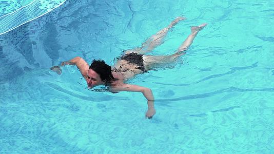 穿着比基尼泳衣的妇女在游泳池水中放松视频的预览图