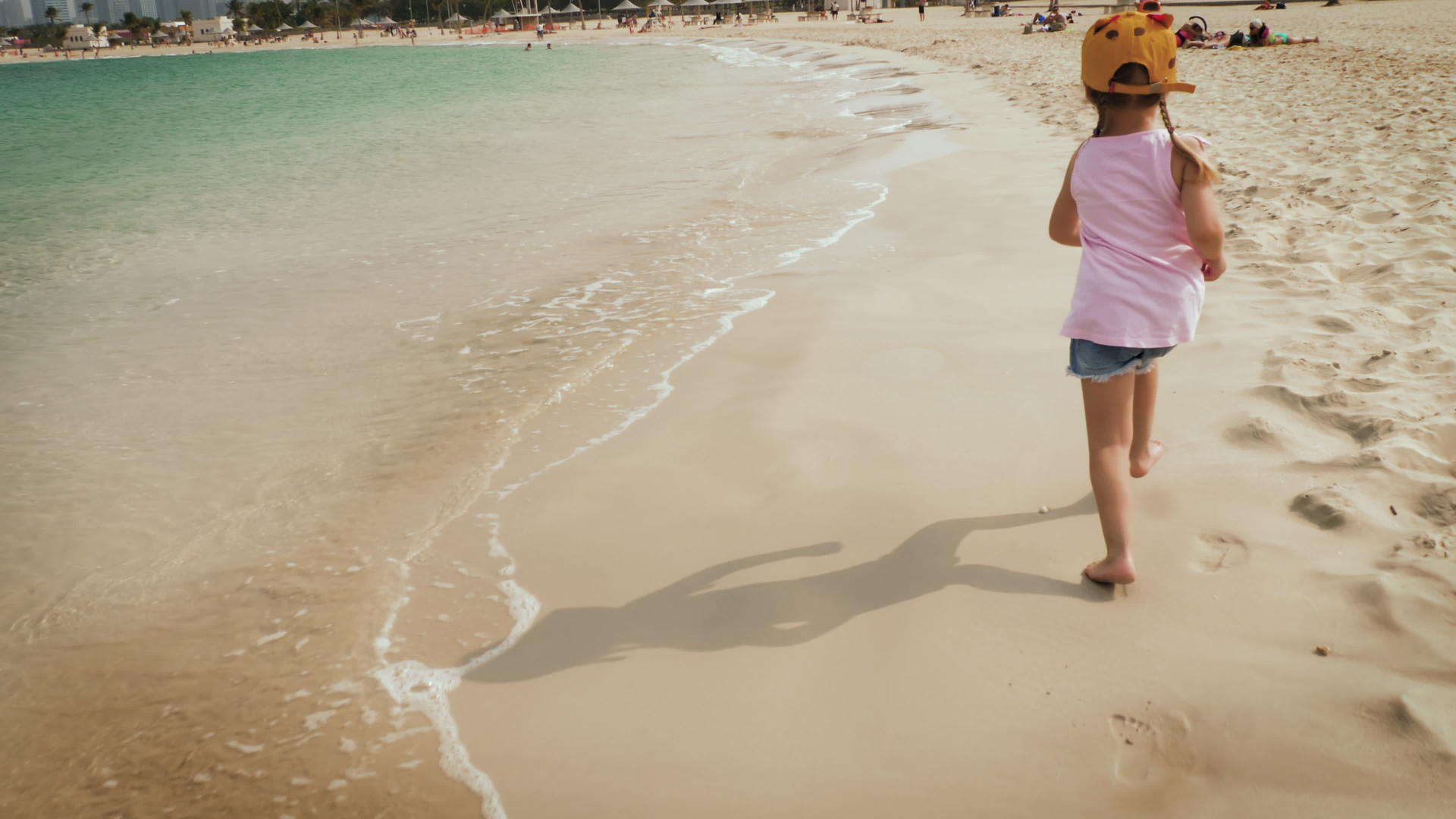 一个可爱的女孩在海滩上奔跑视频的预览图
