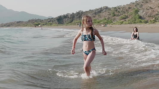 夏天婴儿穿着泳衣在海浪中游泳视频的预览图