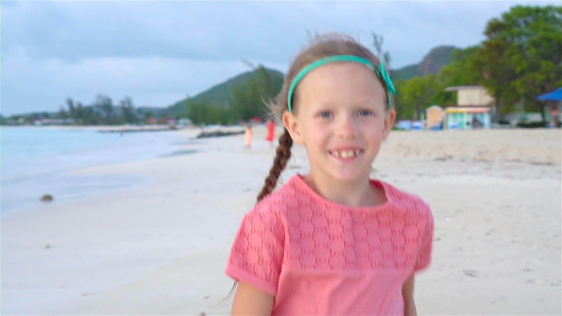 可爱的小女孩女孩在海滩上戴着帽子视频的预览图