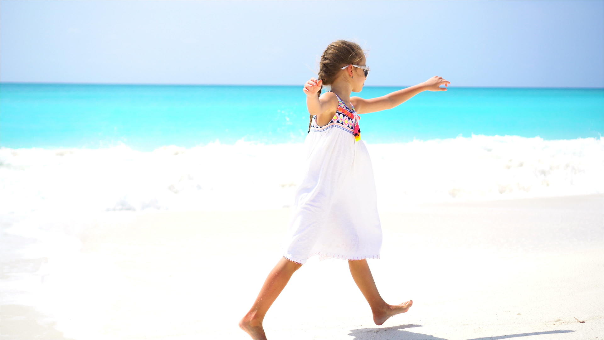 可爱的小女孩在狂喜度假期间在海滩上散步视频的预览图