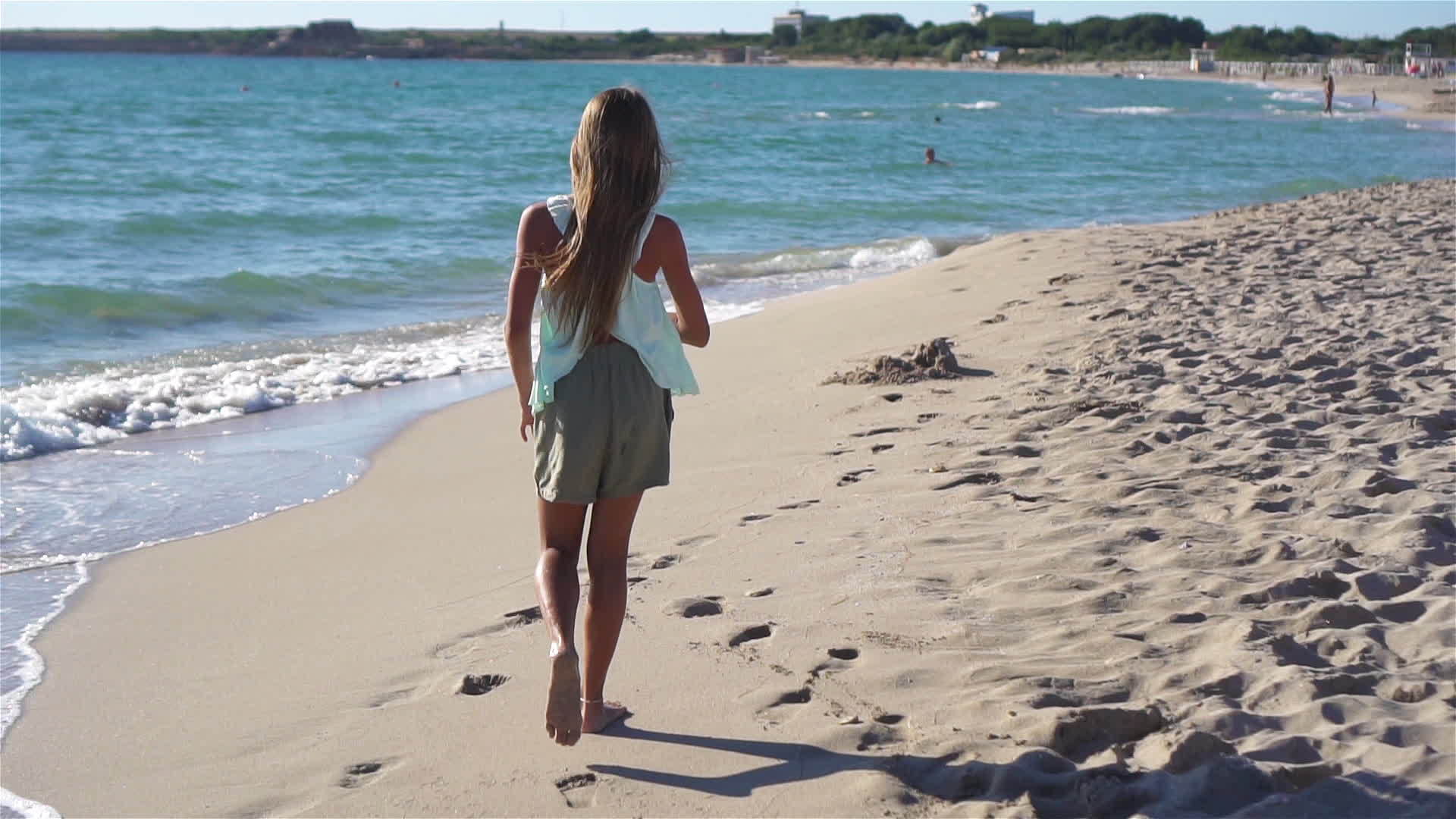 暑假期间可爱活跃的小女孩在海滩上玩耍视频的预览图