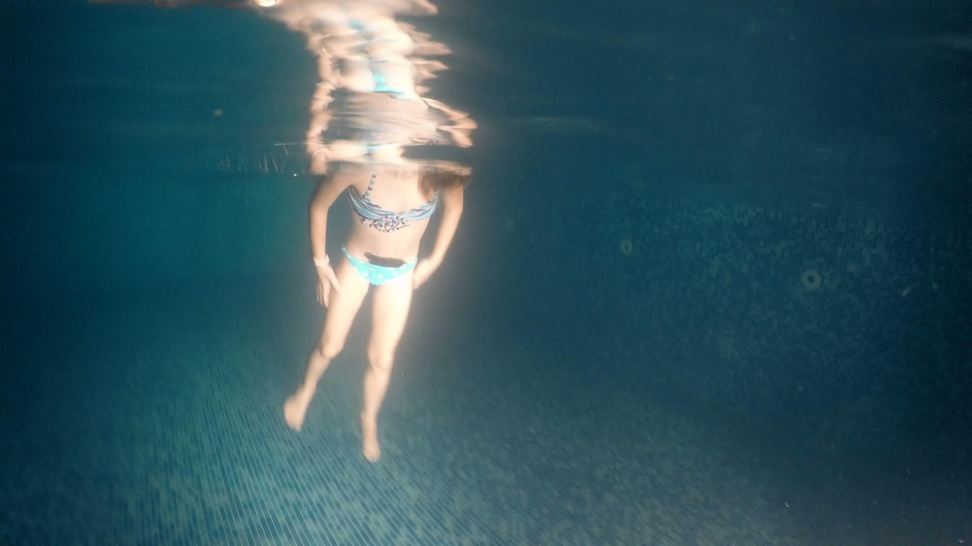小女孩在黑暗的游泳池里翻水下风景视频的预览图