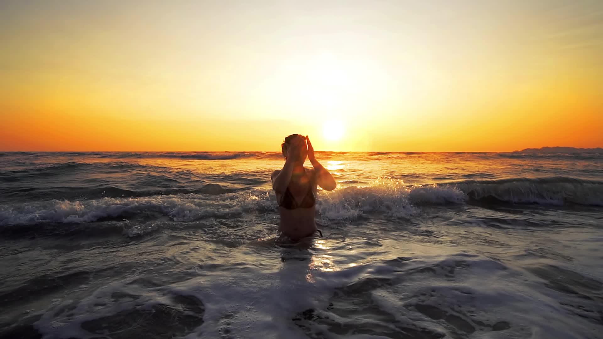 当我在热带海滩日落时我坐在海里像电影一样坐得很慢视频的预览图