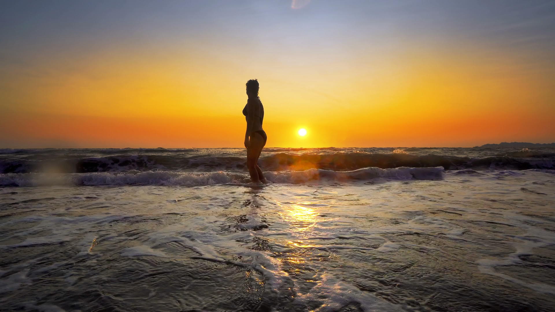 快乐的女人性感完美的身体在日落时在海滩上玩耍和喷水视频的预览图