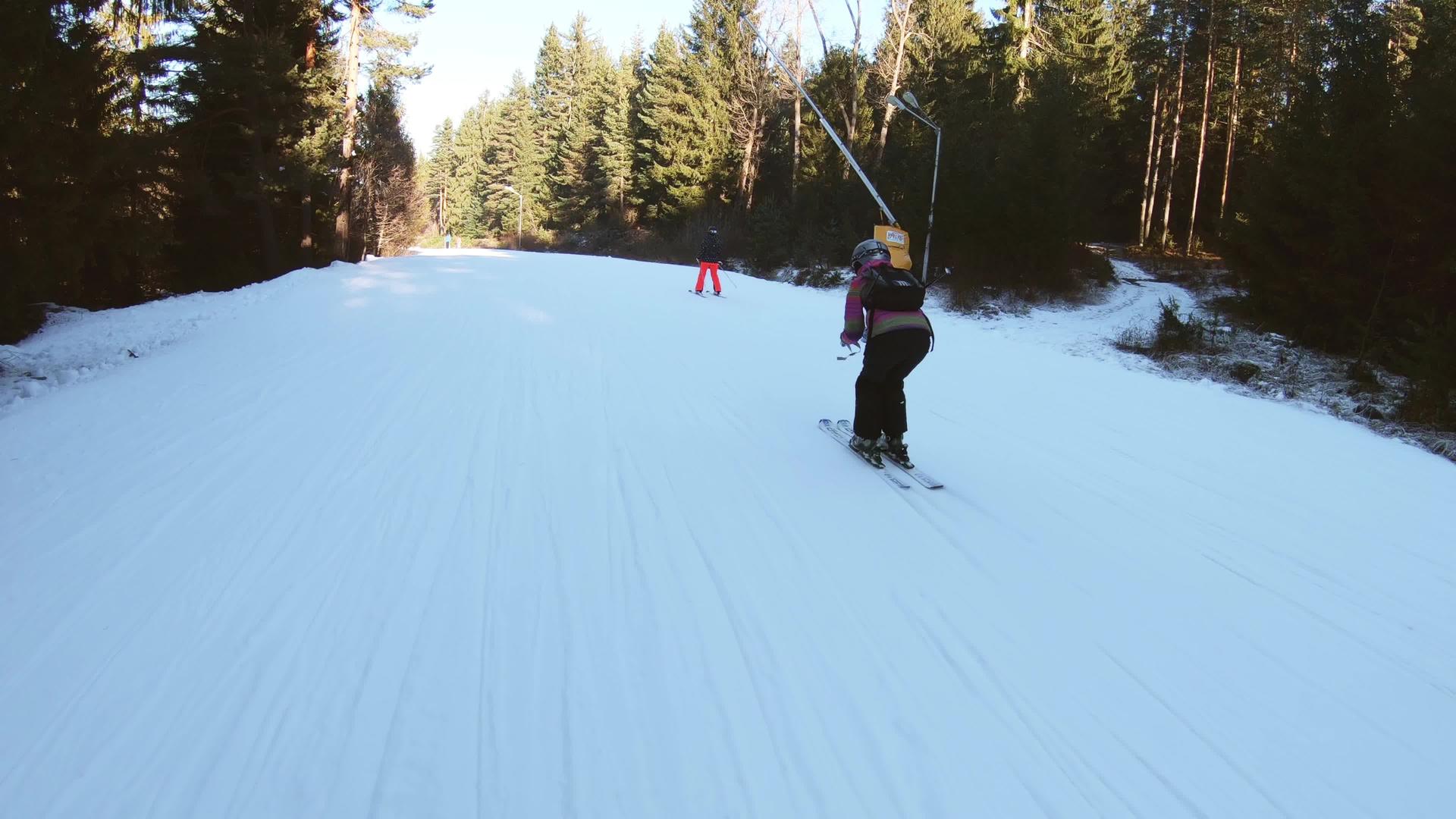 年轻女孩度过了沿着斜坡下游滑雪的假期视频的预览图