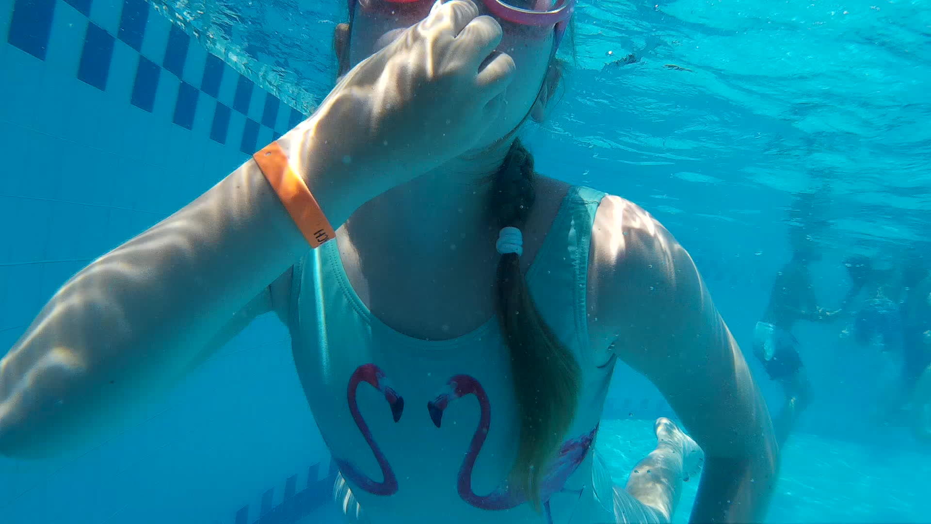 小女孩在游泳池里戴着潜水护目镜游泳视频的预览图