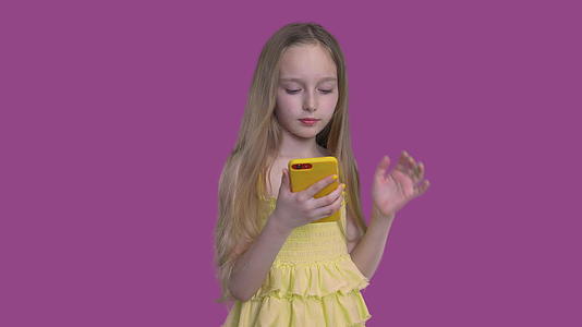 小caucasian女孩看着手机视频的预览图