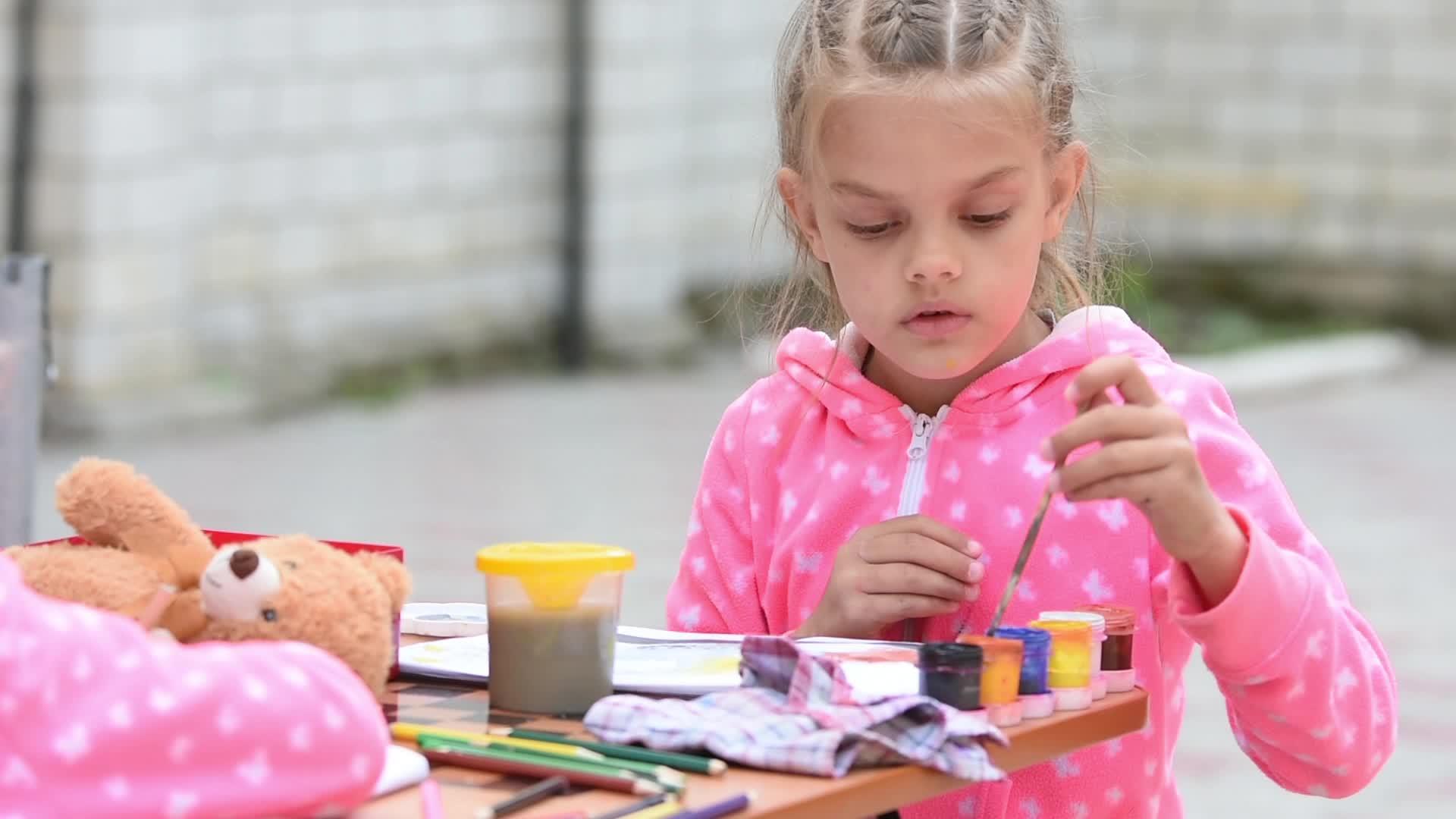 一个7岁的女孩在专辑中选择了正确的彩色墨水画和另一个女孩坐在一起视频的预览图