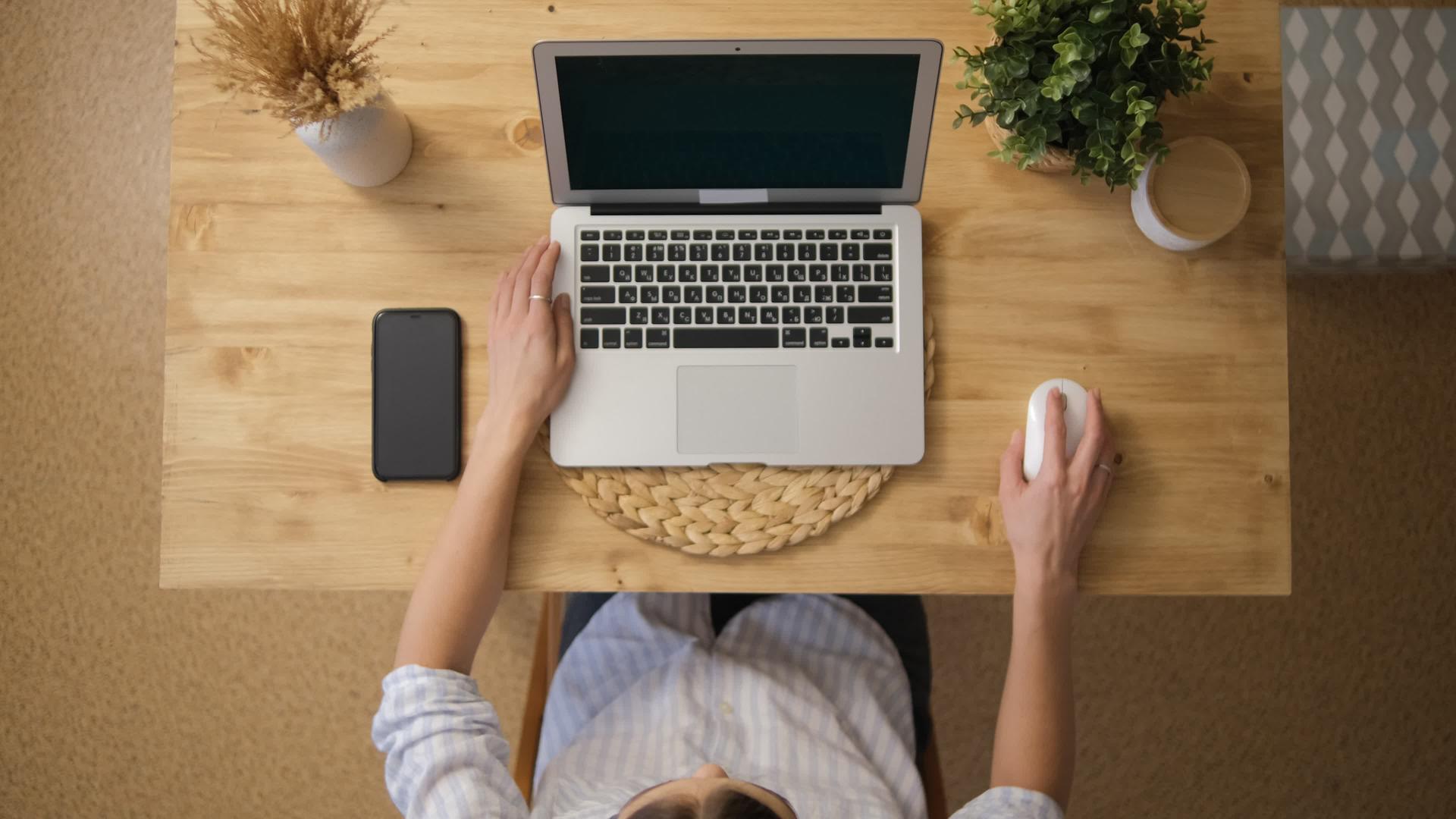 女孩坐在笔记本电脑的顶部通过互联网远程工作视频的预览图