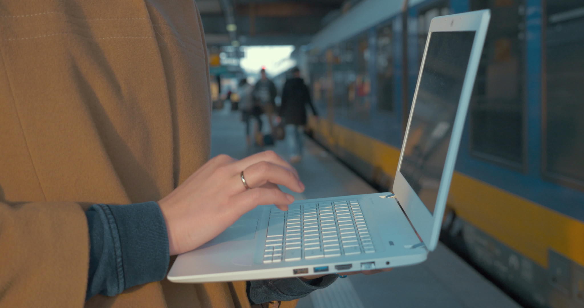 在火车站使用膝盖电脑的妇女视频的预览图