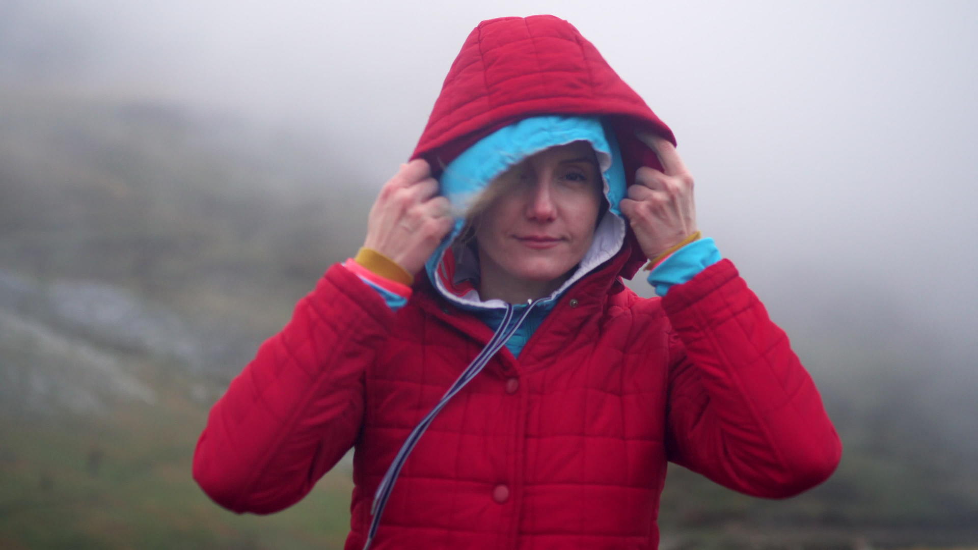 山上女孩和登山者的视频肖像戴着头罩秋天的寒冷天气充满了雾视频的预览图