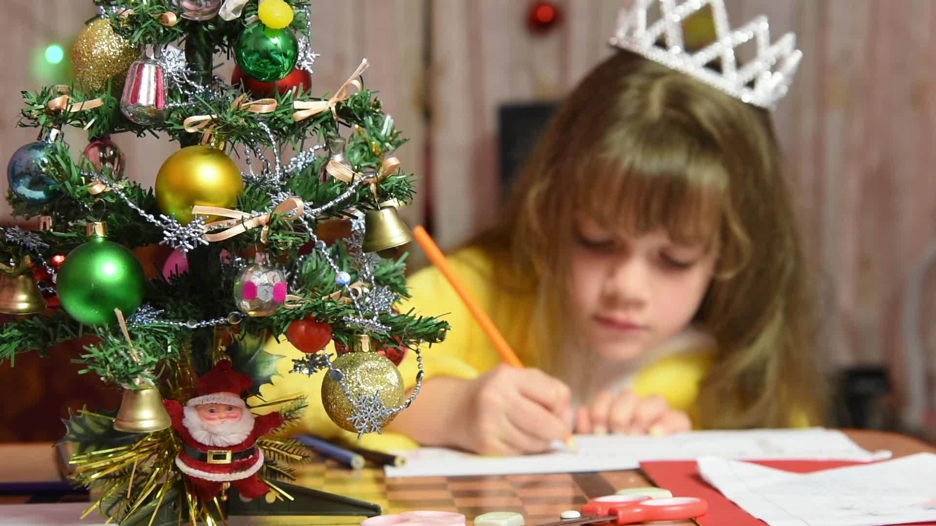 女孩在桌子上画圣诞图案注意她面前的毛树视频的预览图