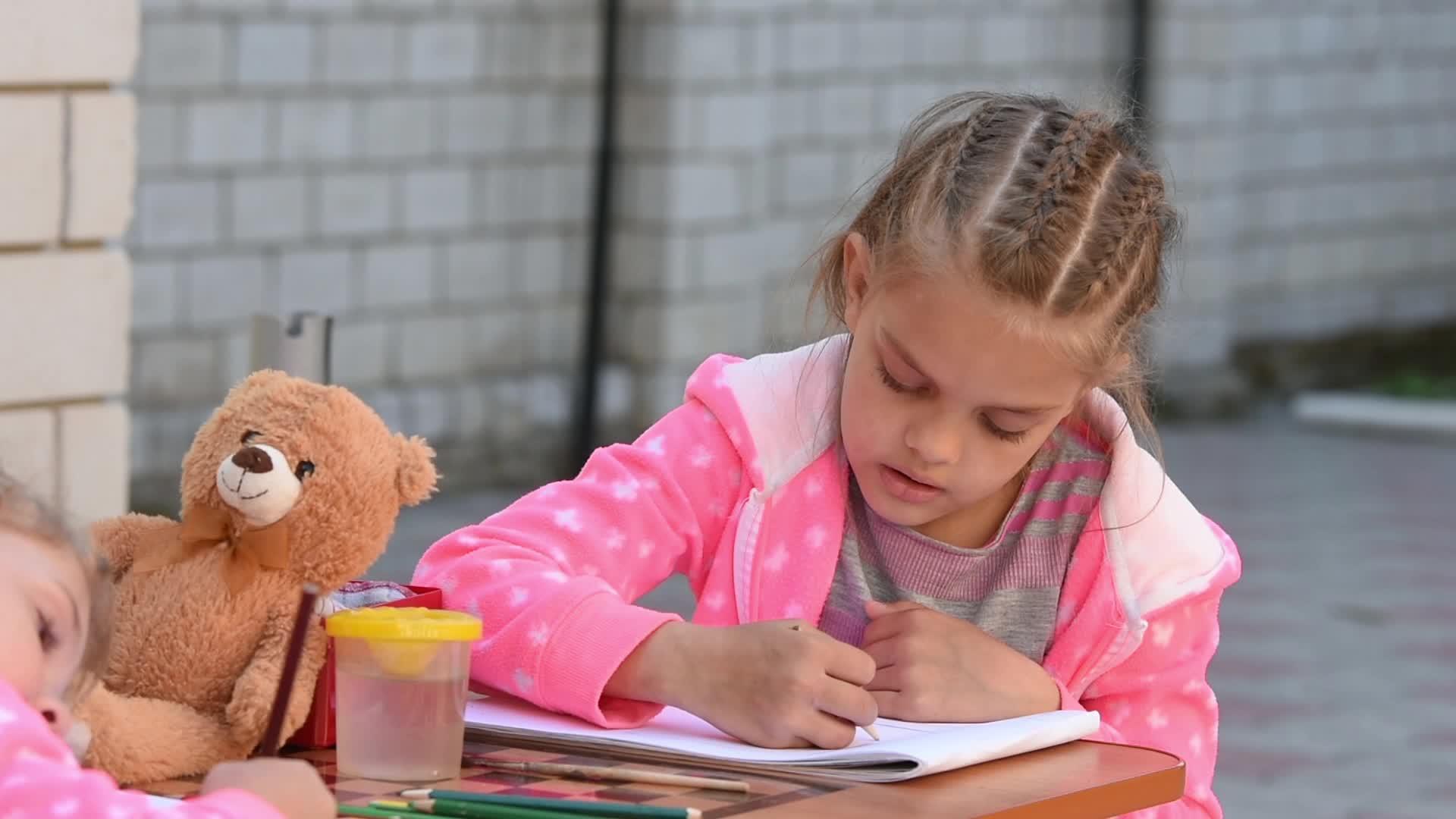 热情的七岁女孩在画册上画画视频的预览图