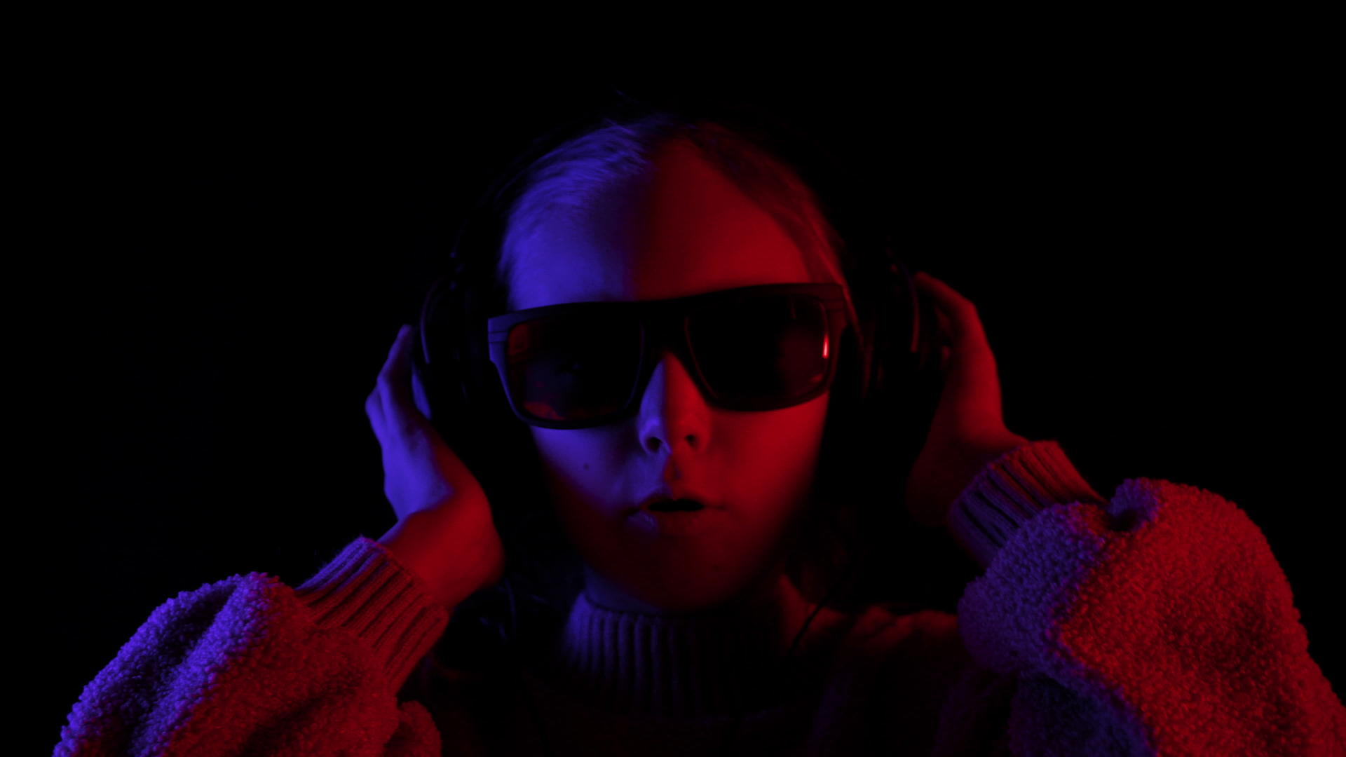 女孩们在黑暗中用耳机和太阳镜唱歌视频的预览图