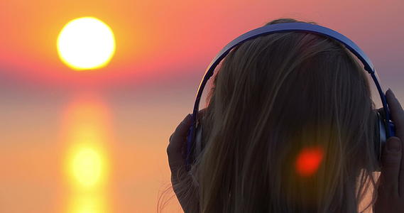 女孩听音乐看日落场景视频的预览图