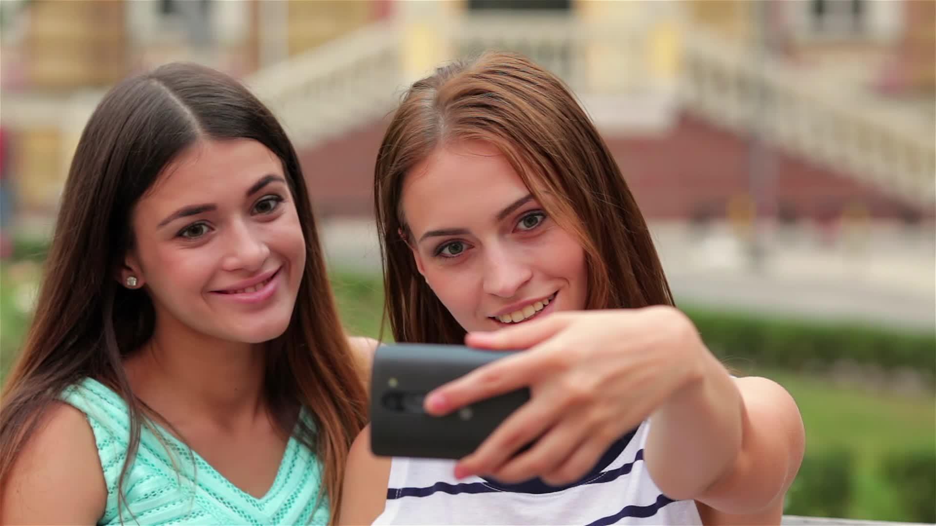 微笑女孩用智能手机相机自拍视频的预览图