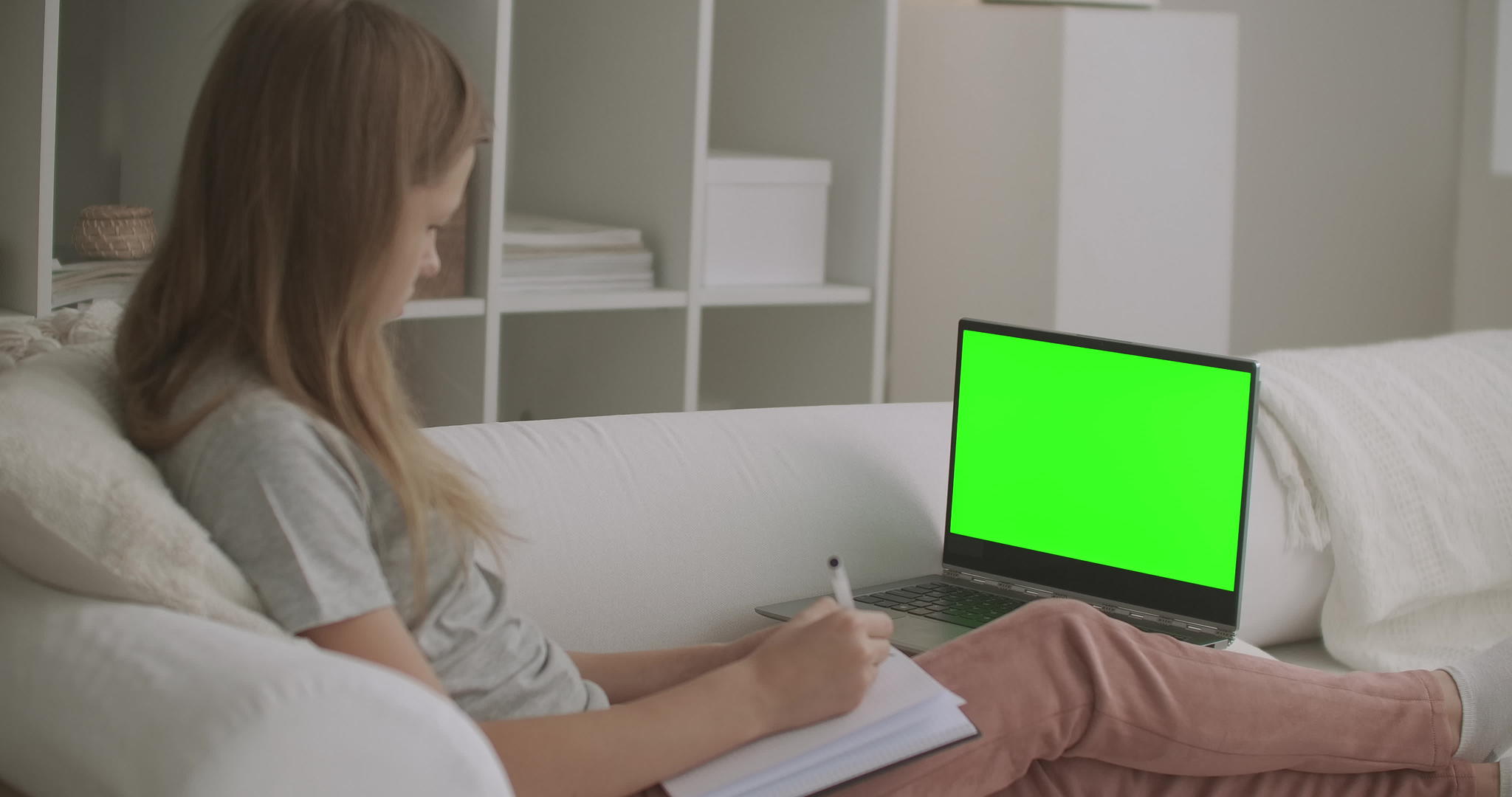 女学生正在用绿屏笔记本电脑观看色度关键技术视频的预览图