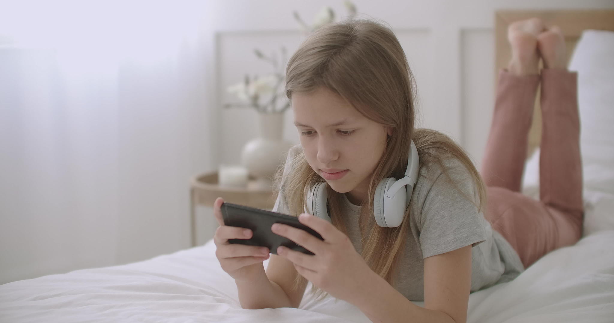 女孩躺在床上在智能手机上聊天使用应用程序与朋友在线视频的预览图