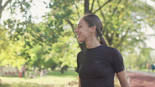 快乐的健身女孩在阳光明媚的秋天在公园步视频的预览图