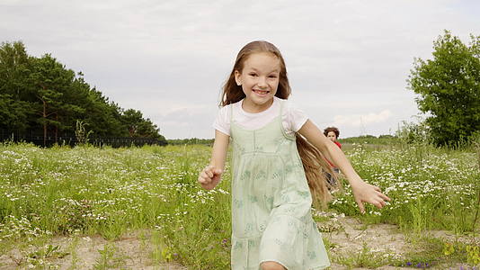 那个兴奋的女孩在夏天的田野里跑着前置摄像头女孩在花草坪上视频的预览图