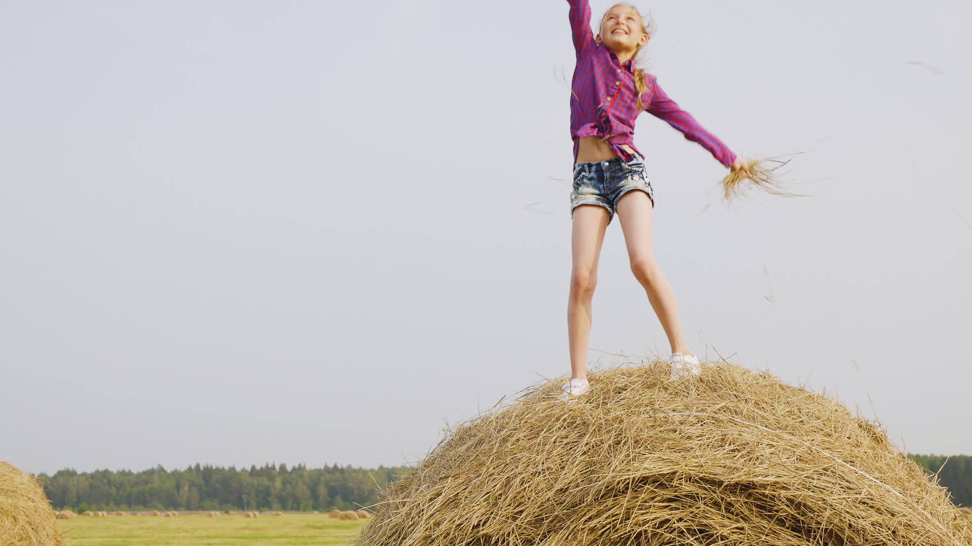 女孩站在农村的草堆上手里拿着稻草跳舞视频的预览图