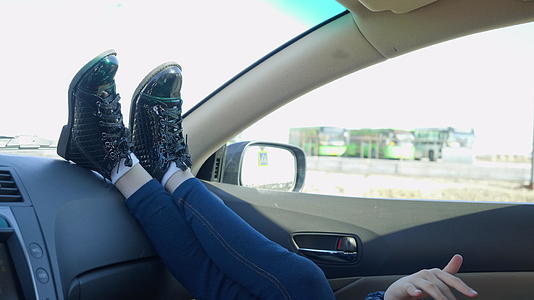 女孩在车里移动她的腿和手臂视频的预览图