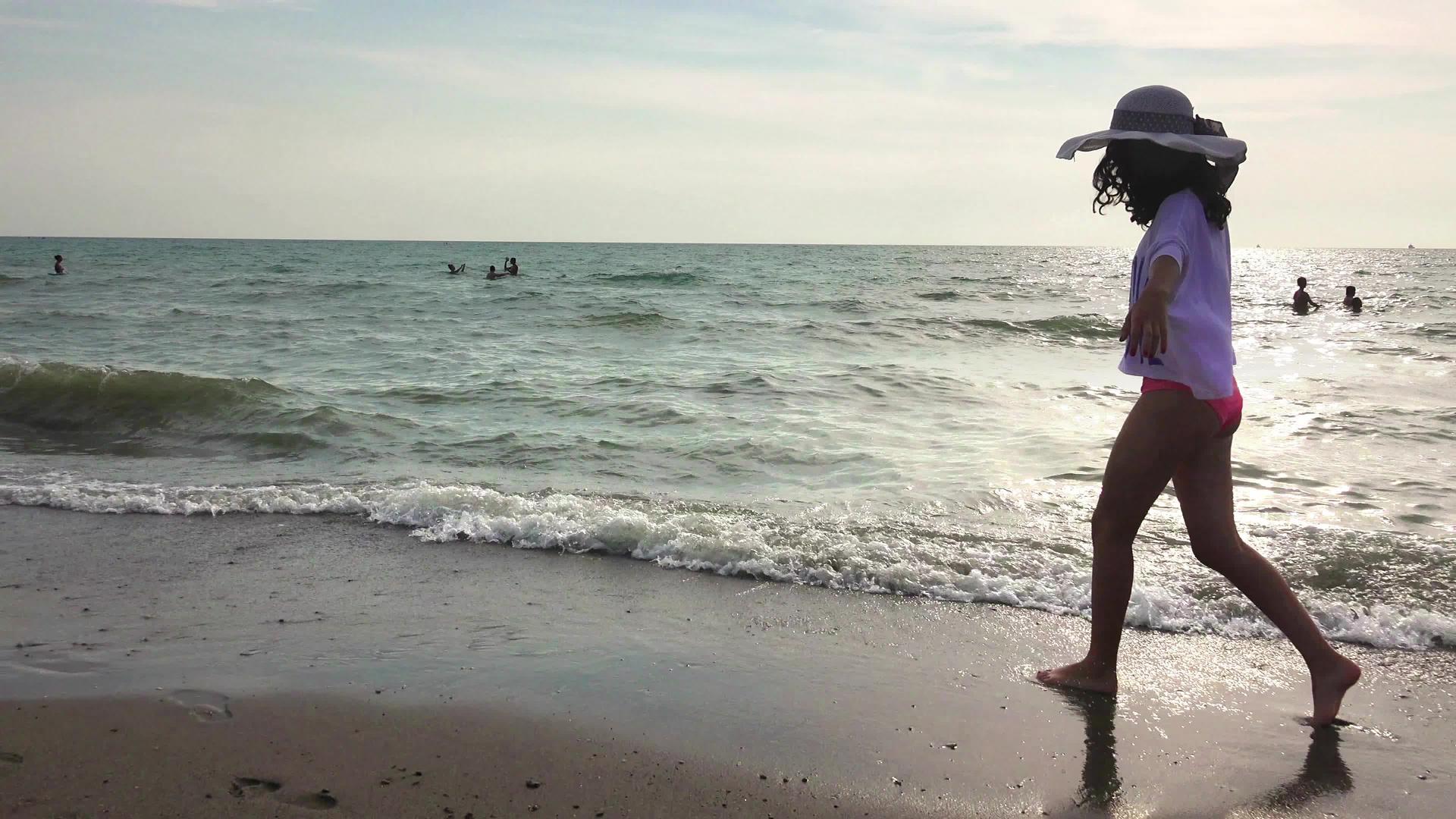 日出日落时戴着帽子的快乐女孩在豪华岛享受欢乐视频的预览图