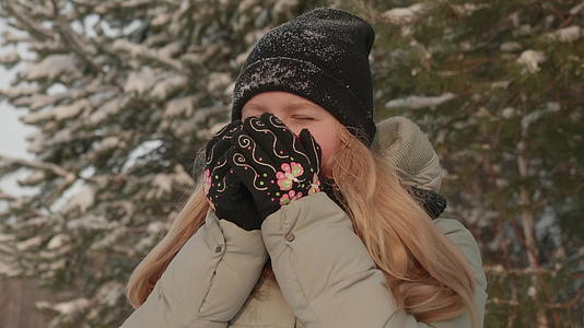 女孩享受下雪的滋味年轻女性在森林里穿着毛衣视频的预览图