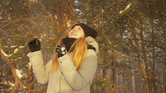快乐的女孩和女孩享受冬冬松树森林下的雪阳光明媚戴头罩视频的预览图