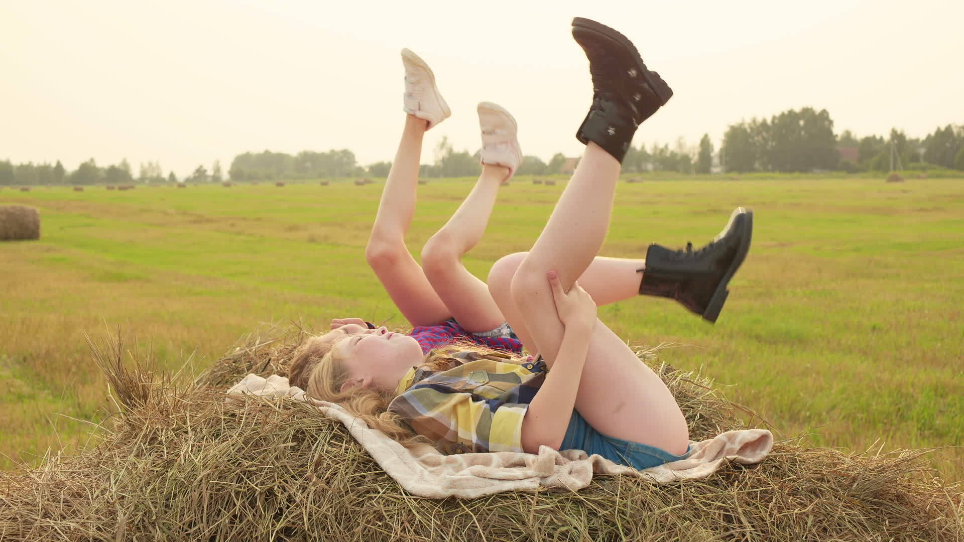 女孩和少年躺在干草堆上快乐的女孩在秋天的干草堆上摇摆视频的预览图