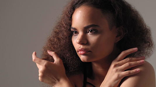 害怕的非裔美国年轻女性站在灰色背景上孤立的黑色视频的预览图