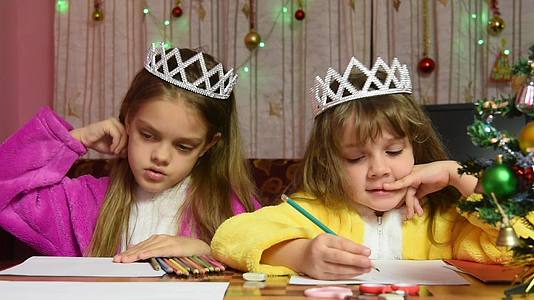 两个穿着睡衣的女孩坐在桌子旁把头埋在手里给圣诞老人写信视频的预览图