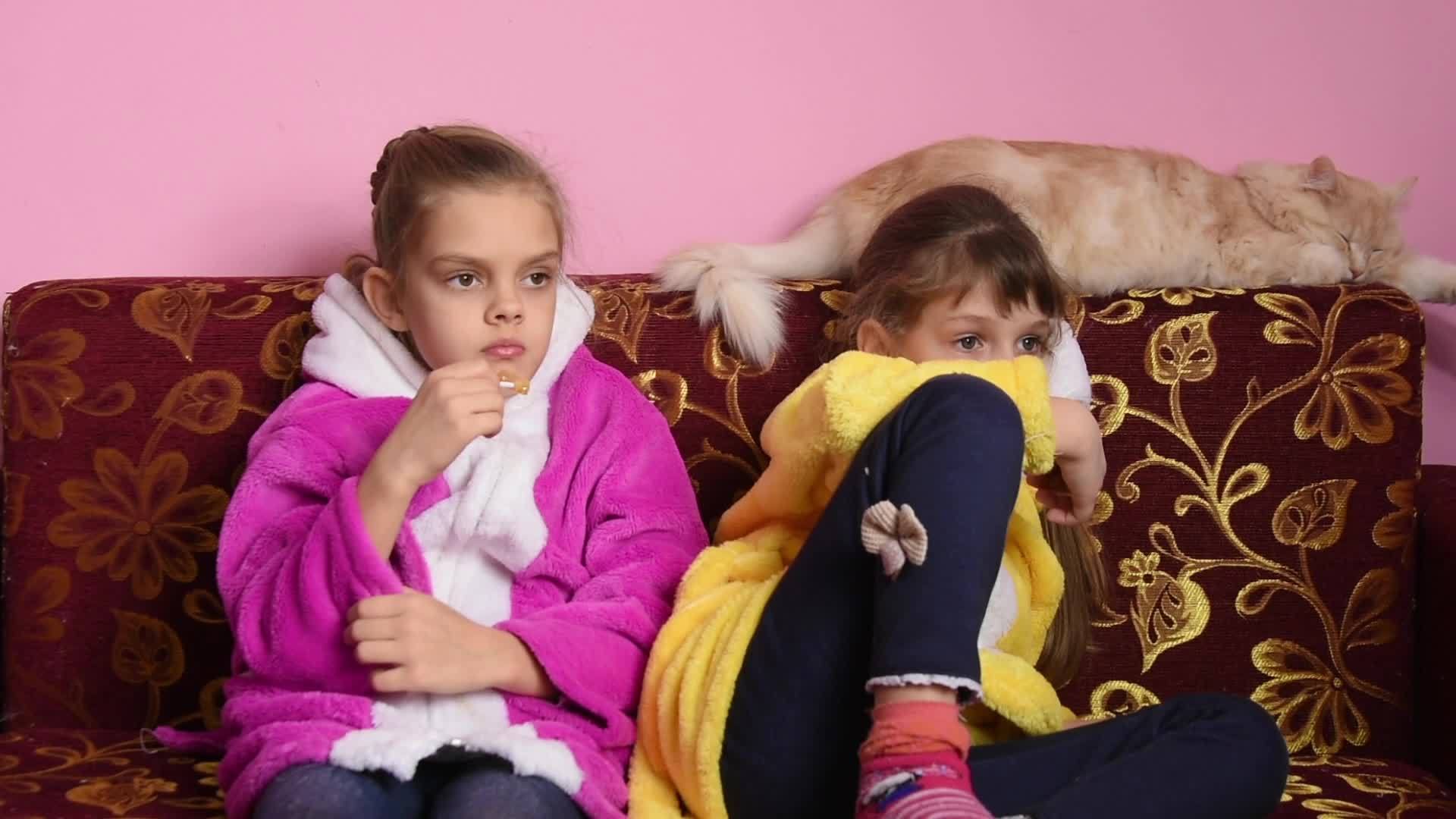 两个女孩坐在沙发上热情地看电视节目视频的预览图