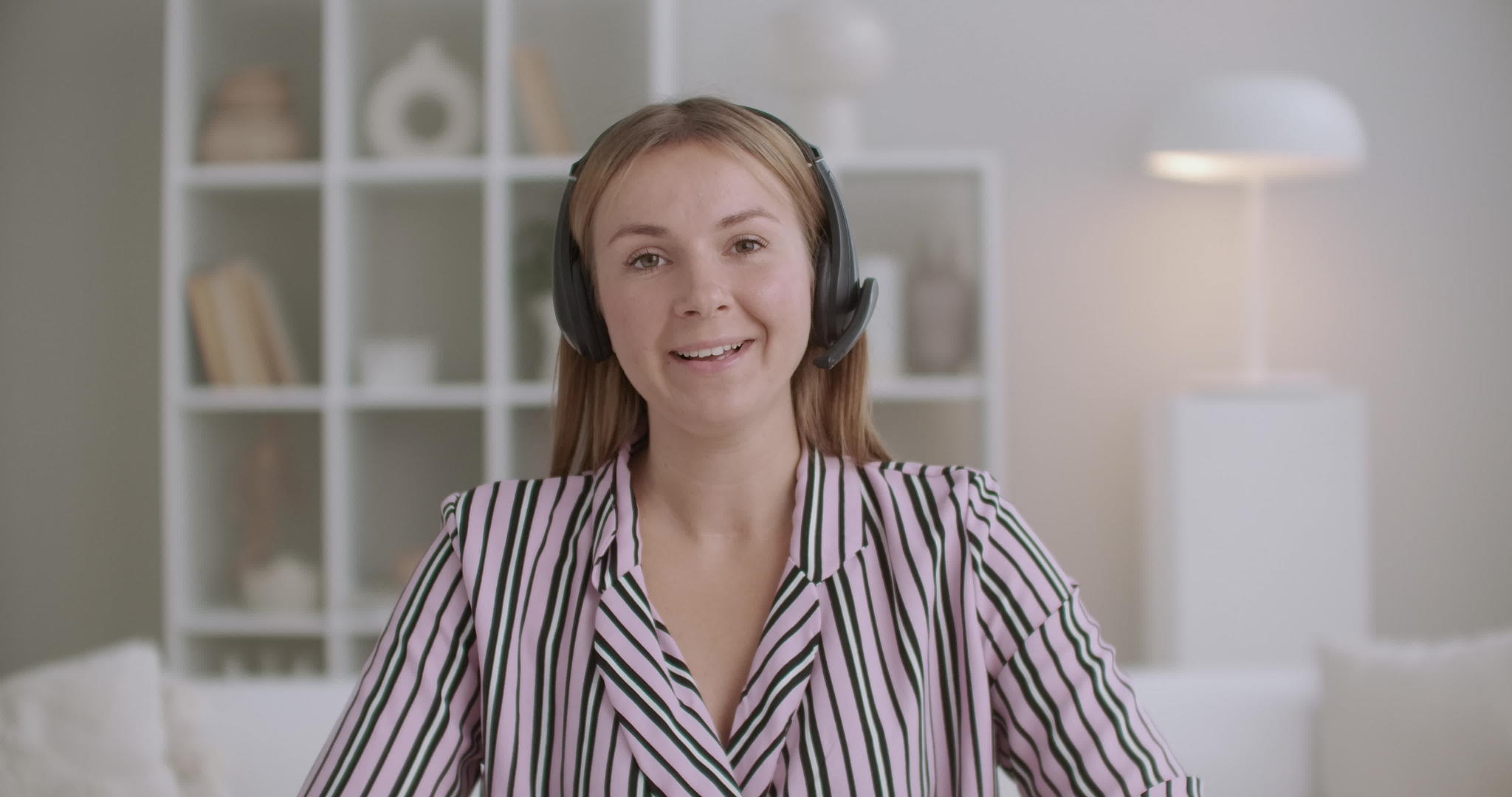 年轻女性专家在家工作时使用麦克风无线耳机视频视频的预览图