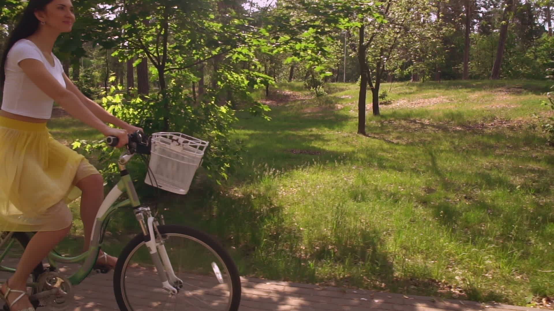 美丽的女孩在公园里骑自行车视频的预览图