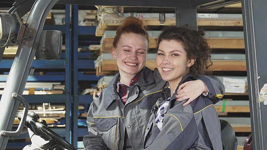 两个快乐的女工厂工人拥抱着对着镜头微笑视频的预览图