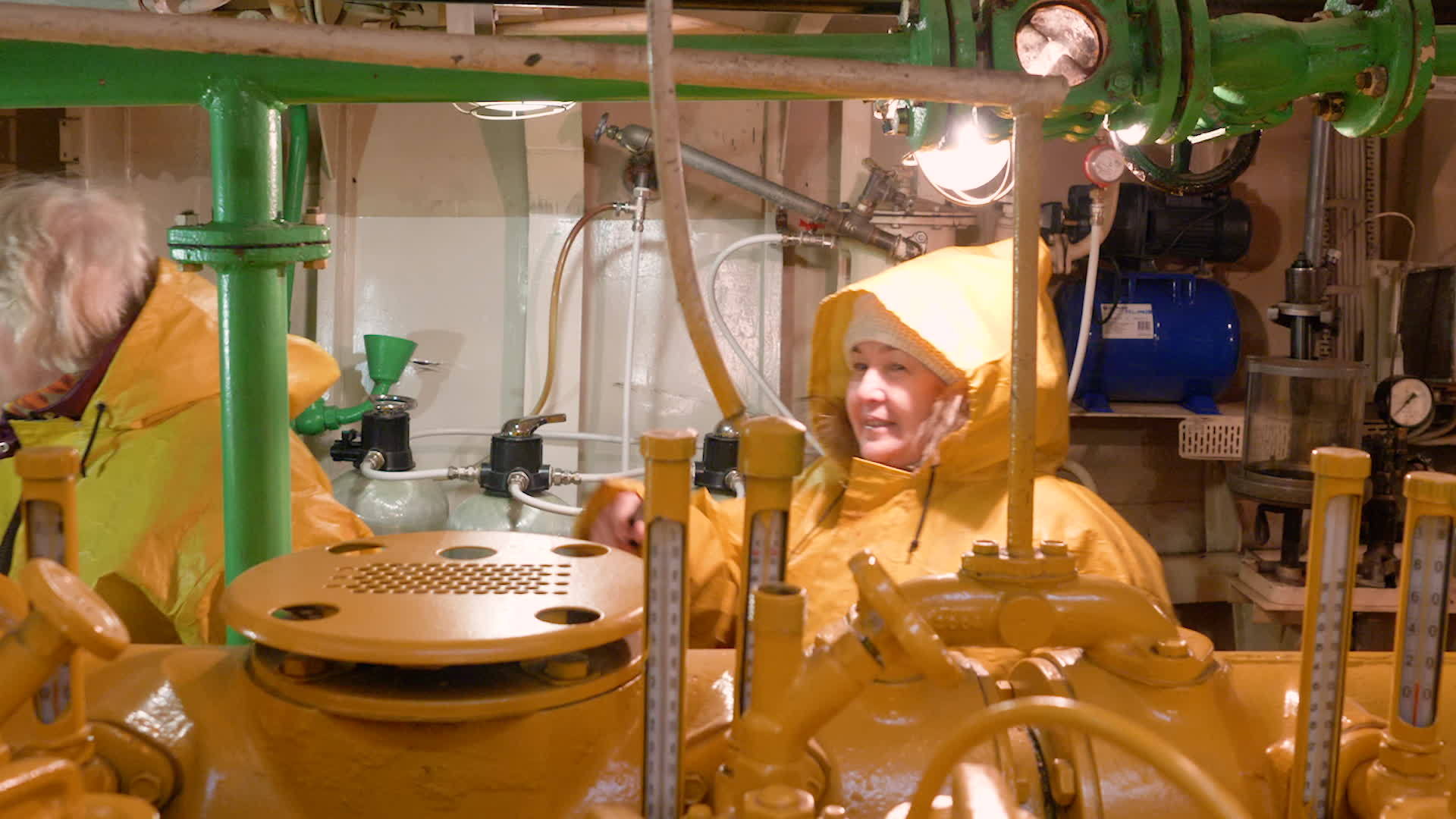 女修理工穿着黄色雨衣检查Norway船上的发动机室视频的预览图