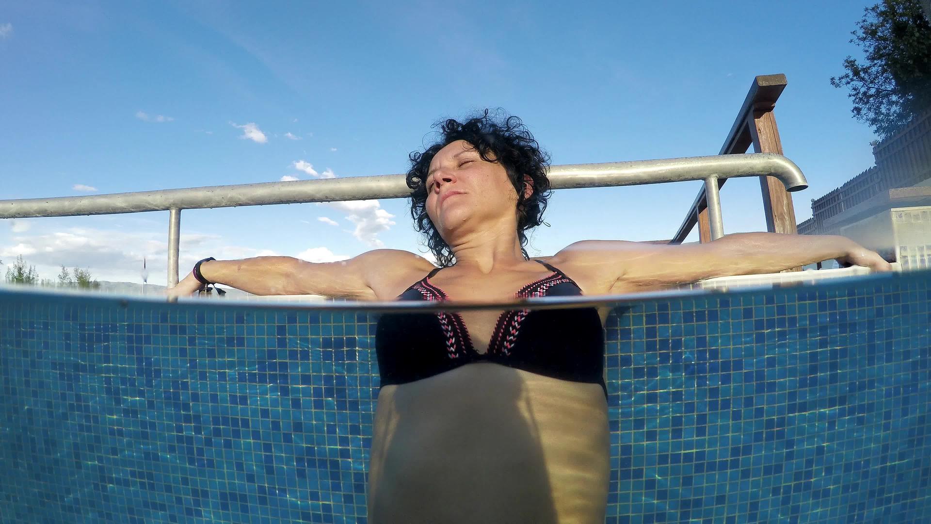 一半的性感女性在热温泉水池中放松在水下拍摄视频的预览图
