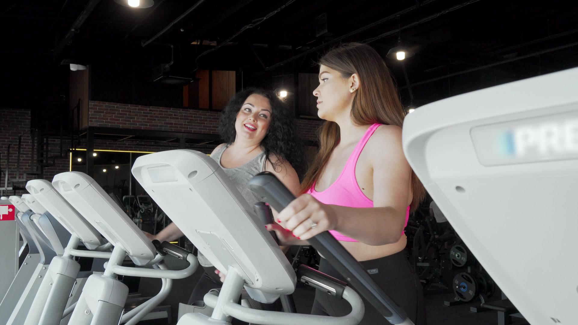 另外两个大女人在健身房工作时用外科教练说话视频的预览图