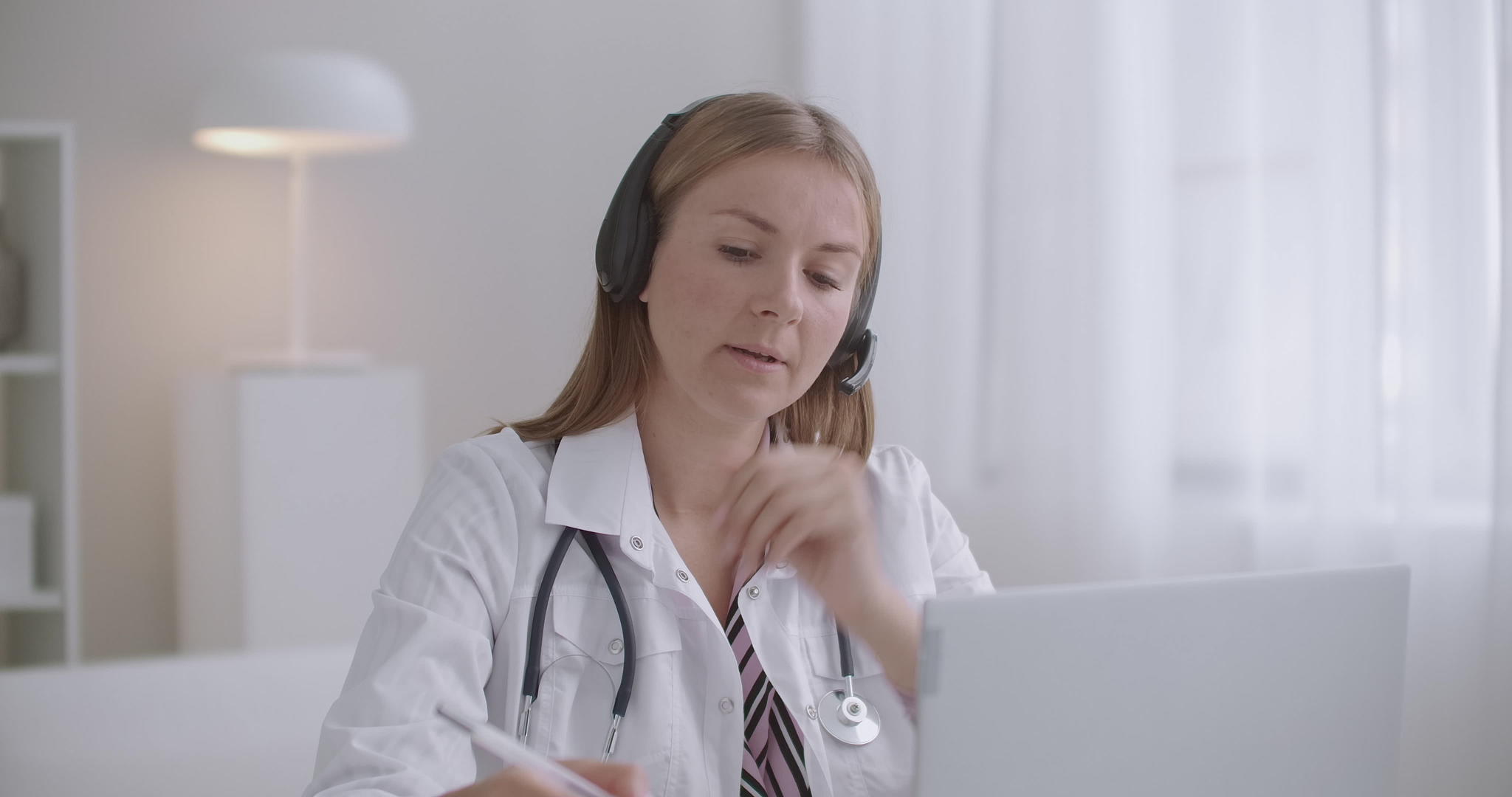通过笔记本电脑与患者在线交流的年轻女医生使用视频视频的预览图