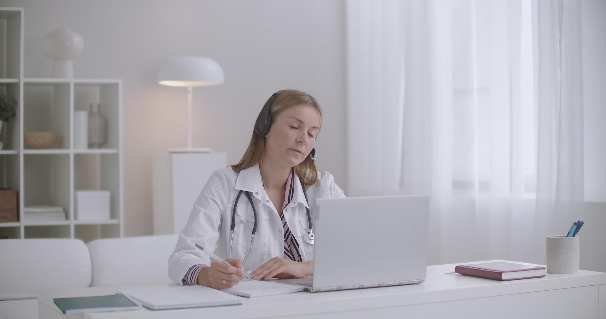 女医生通过膝盖电脑的视频电话与患者或同事进行远程交谈视频的预览图