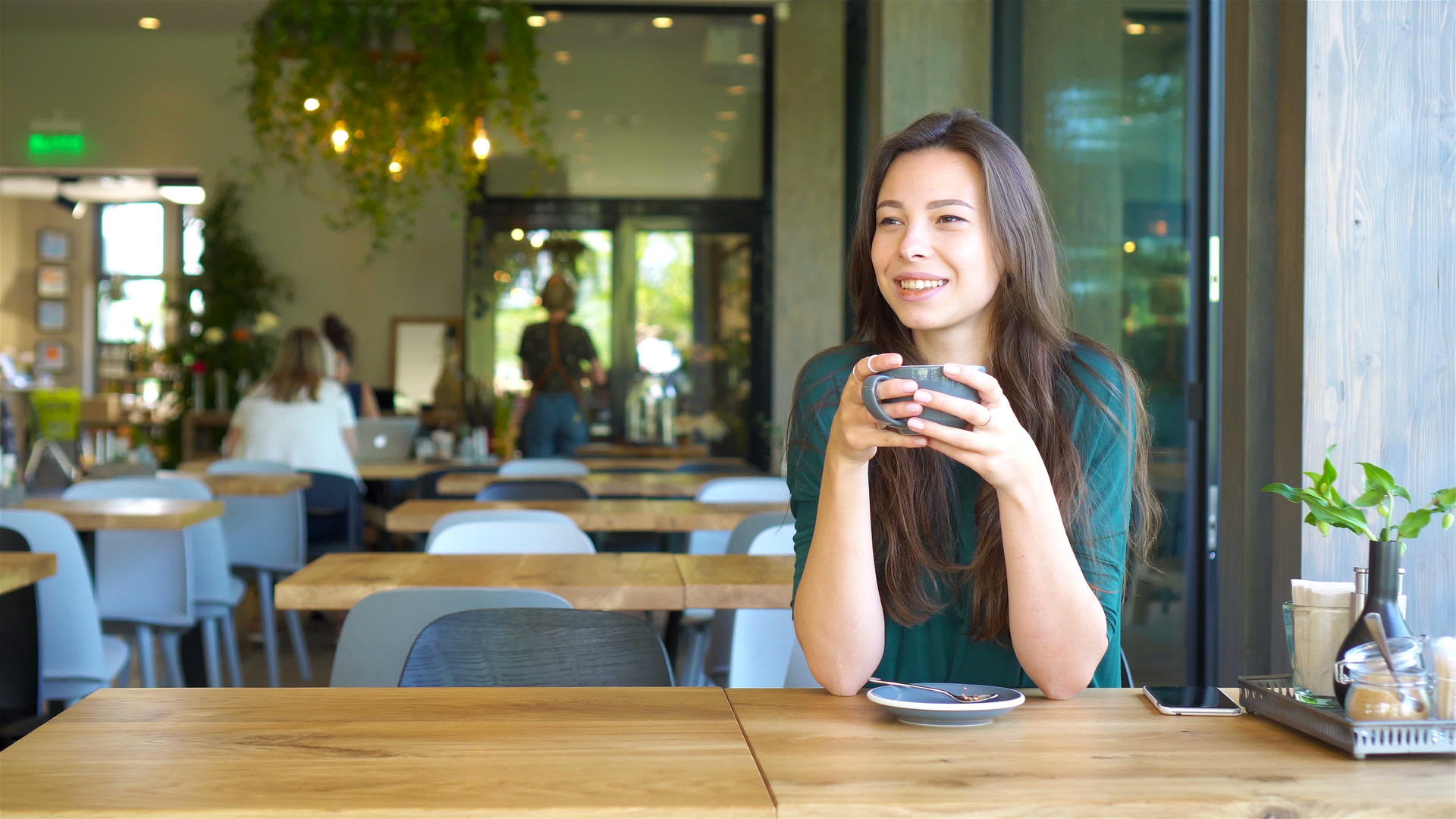年轻迷人的年轻女性在业余时间独自坐在咖啡店喝咖啡视频的预览图