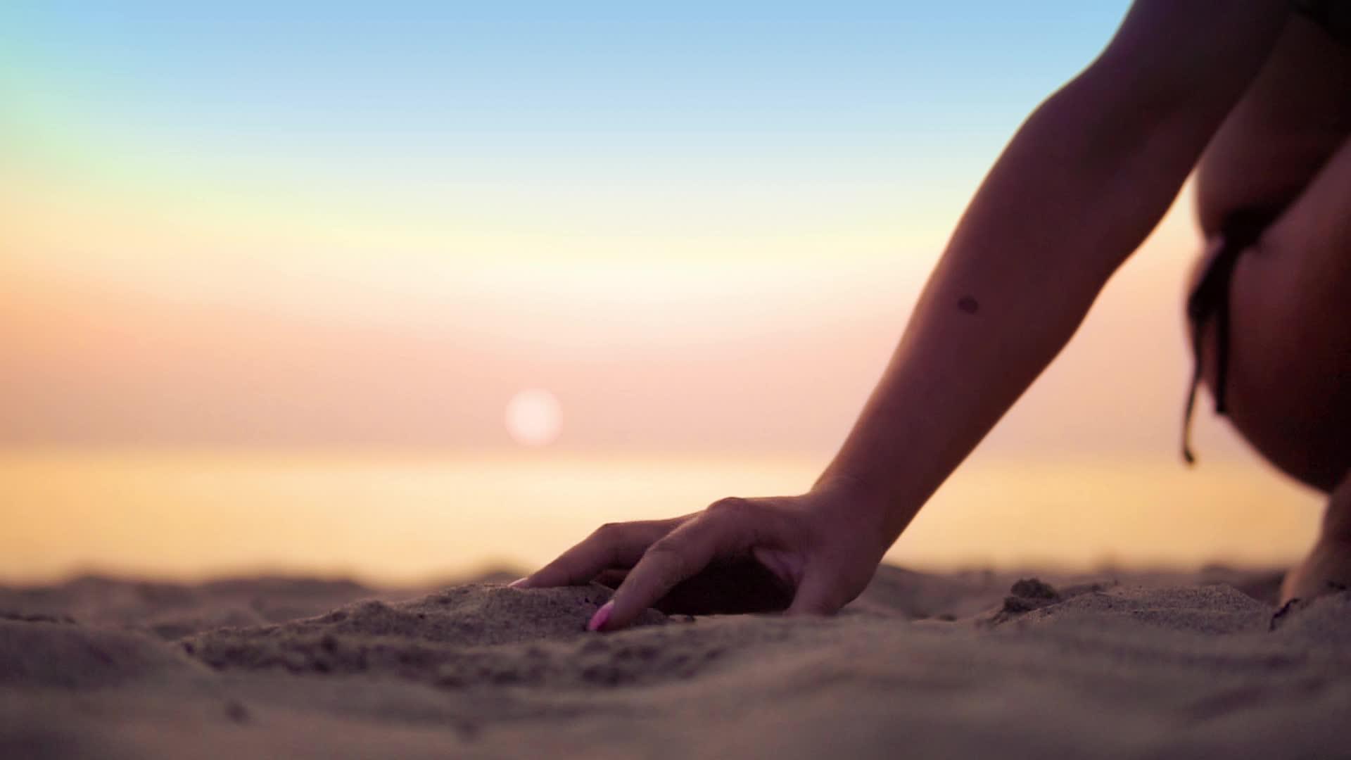 在海边日落时用手撒沙子快乐地度假自由、快乐、自然地旅行视频的预览图