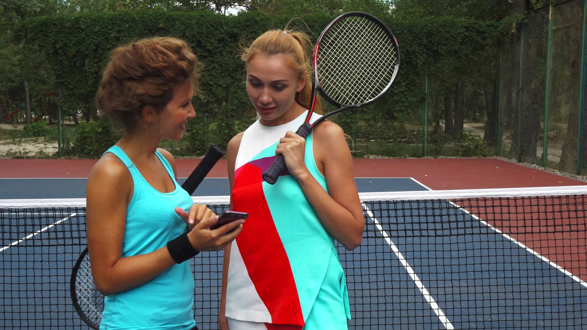 在分享智能手机的同时有两个网球女孩在讨论视频的预览图