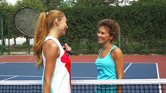 两个女孩在网球场打招呼视频的预览图